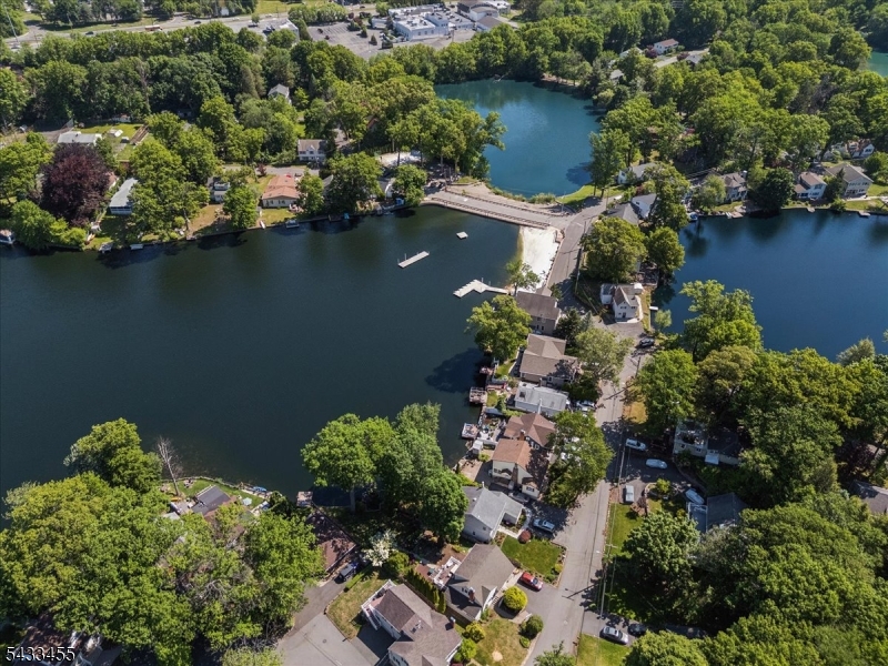 Experience lakefront living at its finest in sought after Rainbow Lakes. This beautifully maintained 3 bedroom, 2 full bath home is a true gem, featuring a brand-new luxurious designer bathroom, a newly updated kitchen with brand new -never used stainless steel appliances, gleaming hardwood floors, and stunning custom woodwork surrounding the fireplace, living room and sunroom. Unwind on the expansive deck overlooking the lake while taking in breathtaking sunset views. Peaceful, inviting, and completely move in ready. This is the lifestyle buyers have been waiting for.