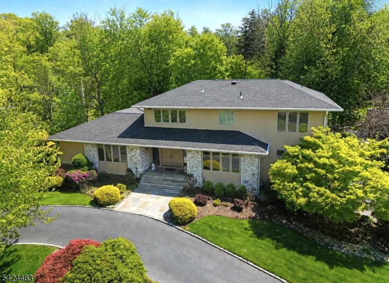Located in the prestigious Deerfield section, this sprawling 5-BR, 4.1-bath home offers uncompromising elegance with total functionality. The interior impresses with a soaring-ceiling living room anchored by a striking built-in bar and gas fireplace, seamless exterior access, and a large family room for relaxation. The chef's eat-in kitchen is a standout, boasting an oversized island, custom cabinetry, premium appliances, and deck access. A convenient 1st-floor laundry is just off the kitchen. The 1st-floor primary suite is a true sanctuary with high ceilings, dual walk-in closets, and a spa-inspired updated bath with heated floors, dual sinks, and an oversized shower. The second level offers 3 generous bedrooms and 2 well-appointed full baths. The expansive lower level is a true destination, featuring a home gym, rec room, and kitchenette. A private 5th bedroom with a full bath & separate exterior access is perfectly suited for guests. Outside, the expansive deck serves as an outdoor living room for large-scale entertaining, overlooking a stunningly flat backyard, a rare find! This exceptional home is complete with a whole-home generator, Tesla charger, and prior town approval for a pool. Prime location near top-rated schools, local dining, shopping, and Midtown Direct train stations for an easy NYC commute. BEST AND FINAL MAY 19th @ 2:00pm. Guidelines loaded in GSMLS.