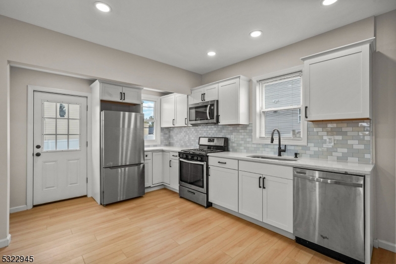 Updated and upgraded! This charming colonial is much larger than it appears! Located just steps from Hillside Avenue School & a short walk to award-winning downtown Cranford, this is an unbeatable location. Enter into the enclosed front porch, providing the perfect mudroom or space for additional storage. Inside, a warm foyer welcomes you with original millwork and classic staircase, setting the tone for the rest of the home. The formal living room provides generous entertaining space and flows into a bonus office/den space just off the main floorplan, providing the perfect homework or work from home setup. Just beyond, the formal dining area opens into brand new kitchen with white cabinetry, quartz countertops, new stainless steel appliances, and numerous windows providing natural light and views of the yard. Upstairs, there are 3 sizeable bedrooms and the brand new full bath. A walk-up, finished attic provides the 4th and final bedroom. The basement provides a laundry area, a second brand new full bathroom, and plenty of storage space. The backyard provides green space and an exceptional, expanded blacktop driveway with parking with 4 cars (fully fenced and gated, as well). Move right in!
