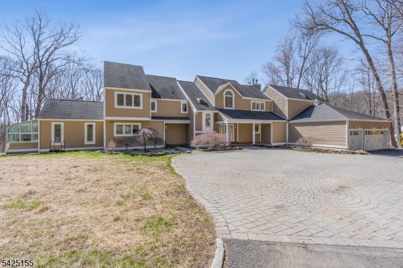 Modern masterpiece located on private 5 acre lot! Enter into a 2-story foyer leading to a skylit great room with FP open to a generously sized formal dining room. A 1st floor bedroom with bath offers a versatile space, work from home in a 1st floor office and enjoy the spacious kitchen with adjoining family room and solarium.The 2nd floor primary suite features a gas FP, cathedral ceiling, deck,16 x16 sitting room, two immense walk-in closets and a stunning nearly new spa like bath. Three additional bedrooms, two newer baths(1 ensuite) and an airy loft complete the second floor. More space is found in the finished walkout with large rec room, kitchenette, newer full bath, music room, craft room and storage. 3- car garage with Tesla charger. Yard offers firepit area,gazebo, and basketball court. New five bedroom septic installed 2026. Two new sets of sliding doors in living room 2026. Superb location on a cul-de- street not far from center of town, shopping, NYC trains and highways.