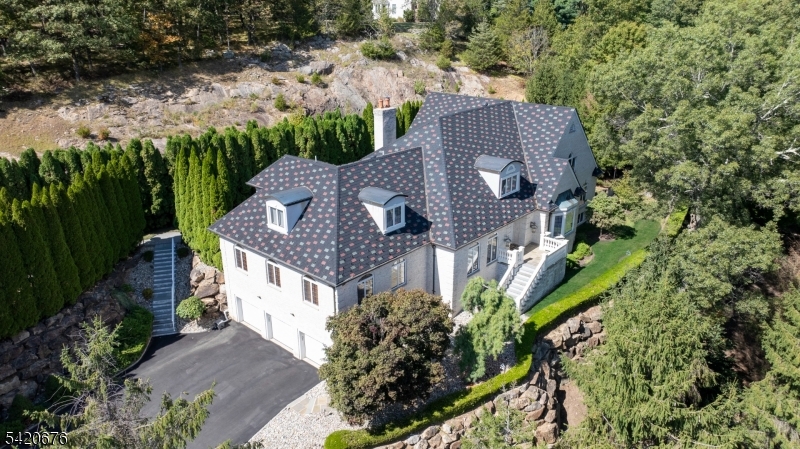 Discover an extraordinary estate featuring a FIRST FLOOR PRIMARY SUITE redefining luxury in Sparta's most coveted enclave situated in the highly sought-after Sawmill Estates neighborhood located just 1 HOUR TO NYC! Nestled on 3.71 acres, 49 Cherokee Court is a 7,600+ Square Foot residence blending classic grandeur with modern refinement. Upon entry you are greeted by a Soaring Two-Story Foyer grand entrance making a stunning first impression. The main level features a Cathedral Ceiling Living Room with overlooking balconies anchored by a stately Fireplace, a Family Room accented by ceiling wooden-beams, elegant Formal Dining Room & Formal Family Room/Office space. The gourmet Eat-In Kitchen is a Chef's delight highlighted by Top-Of-The-Line Appliances, custom-milled Cabinetry & Center Island with Breakfast Bar. The First Floor Primary Suite features a BONUS Adjoining Suite with cozy Fireplace, Walk-In Closet & En-Suite Bathroom including a Dual Vanity Sink, Stall Shower & jetted Soaking Tub. Upstairs you will find 5 spacious Bedrooms with 3 En-Suite Bathrooms completing the space. This Private Oasis getaway is an Entertainers Paradise offering a STUNNING Heated In-Ground Gunite Pool with built-in Hot Tub and gorgeous Marble hardscape surrounded by lush landscaping & a wooded backdrop. Sparta offers the #1 School District in Sussex County. Nearby highly desired attractions Lake Mohawk in Sparta, Lake Hopatcong & Year-Round Resorts Crystal Springs, Minerals & Mountain Creek.
