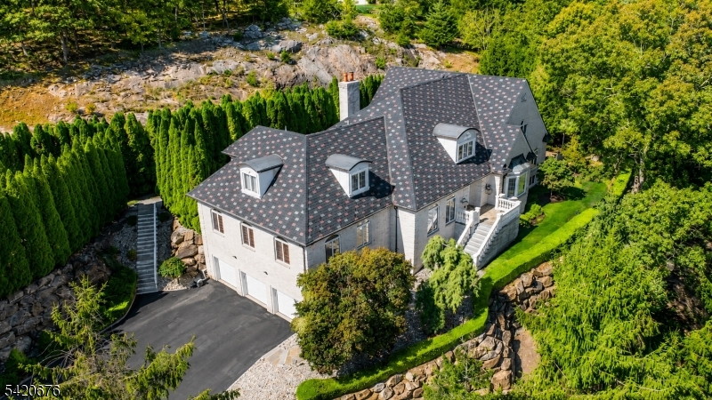 Discover an extraordinary estate featuring a FIRST FLOOR PRIMARY SUITE redefining luxury in Sparta's most coveted enclave situated in the highly sought-after Sawmill Estates neighborhood located just 1 HOUR TO NYC! Nestled on 3.71 acres, 49 Cherokee Court is a 7,600+ Square Foot residence blending classic grandeur with modern refinement. Upon entry you are greeted by a Soaring Two-Story Foyer grand entrance making a stunning first impression. The main level features a Cathedral Ceiling Living Room with overlooking balconies anchored by a stately Fireplace, a Family Room accented by ceiling wooden-beams, elegant Formal Dining Room & Formal Family Room/Office space. The gourmet Eat-In Kitchen is a Chef's delight highlighted by Top-Of-The-Line Appliances, custom-milled Cabinetry & Center Island with Breakfast Bar. The First Floor Primary Suite features a BONUS Adjoining Suite with cozy Fireplace, Walk-In Closet & En-Suite Bathroom including a Dual Vanity Sink, Stall Shower & jetted Soaking Tub. Upstairs you will find 5 spacious Bedrooms with 3 En-Suite Bathrooms completing the space. This Private Oasis getaway is an Entertainers Paradise offering a STUNNING Heated In-Ground Gunite Pool with built-in Hot Tub and gorgeous Marble hardscape surrounded by lush landscaping & a wooded backdrop. Sparta offers the #1 School District in Sussex County. Nearby highly desired attractions Lake Mohawk in Sparta, Lake Hopatcong & Year-Round Resorts Crystal Springs, Minerals & Mountain Creek.