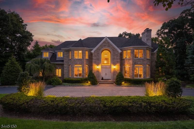 Custom-built in 1993 by its sole owner and designed to entertain, this 5-bedroom, 6-full & 2-half-bath luxury home for sale in Franklin Lakes, NJ sits on over an acre in the top-rated Franklin Lakes school district, with a flat, grassy backyard offering plenty of room for a pool. A circular driveway with a center paver walk leads past an oversized 3-car garage and brick facade to a two-story foyer, where a grand staircase rises beneath a great room with soaring vaulted ceilings, a ceiling fan, palladian windows, built-in cabinetry, and a fireplace opening to a new, maintenance-free deck. A separate living room offers a fireplace of its own. A second staircase winds through a mudroom landing (coat closet, powder room) to a white kitchen with an island, eat-in nook, and walk-in and butler's pantries. Every bedroom has its own en-suite bath, and the primary suite offers a front bump-out, two closets, in-floor heat, a soaking tub, bidet, its own fireplace, and a private balcony. A cherry-trimmed study with a coffered ceiling adds quiet elegance. Downstairs, the finished, furnished walk-out level offers a stone-fireplace family room, two storage areas, concealed plumbing for a future kitchen, a radon system, sump pump, and a 6th full bath beside a gym or office with an egress window and 6th-suite potential. With four fireplaces, five zones of A/C, eleven zones of heat, a walk-up attic, and refinished hardwood floors, this Bergen County luxury estate is ready for its next chapter.