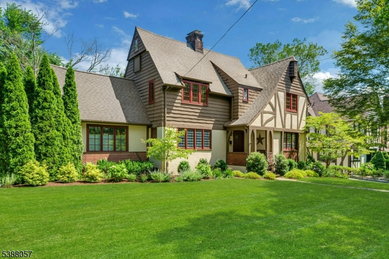 Stunning Home, Ideal Location! This beautiful Tudor in the sought-after Knollwood section of Short Hills blends timeless architectural details with modern updates. With generous main-level spaces, four large bedrooms upstairs and a private outdoor retreat, this home offers the best in comfortable, modern living. An easy-flowing floor plan features a gracious entry foyer, an elegant living room with stone fireplace and a comfortable family room with a soaring cathedral ceiling and access to one of two outdoor patios. The sunlit formal dining room connects to the renovated kitchen featuring GE appliances, Bosch dishwasher and breakfast bar. An adjacent mudroom leads to the attached two-car garage, and a stylish powder room completes this level. Upstairs, the spacious primary suite offers a serene retreat with two closets and a recently renovated bathroom. Three additional bedrooms with ample closet space and a beautifully updated hall bathroom complete this level. The lower level includes a rec room, office, laundry, workshop. Outside, the expansive yard features large flat lawns for play and relaxing and two patio areas, all framed by lush landscaping ensuring privacy. Additional highlights: new windows, hardwood floors, rec lights, CAC, in-ground sprinklers, EV Charger. JUST BLOCKS TO EVERYTHING: trains to NYC, schools and downtown. A rare opportunity to own a fabulous home in a welcoming neighborhood known for its block parties, Halloween Parade and prime location!