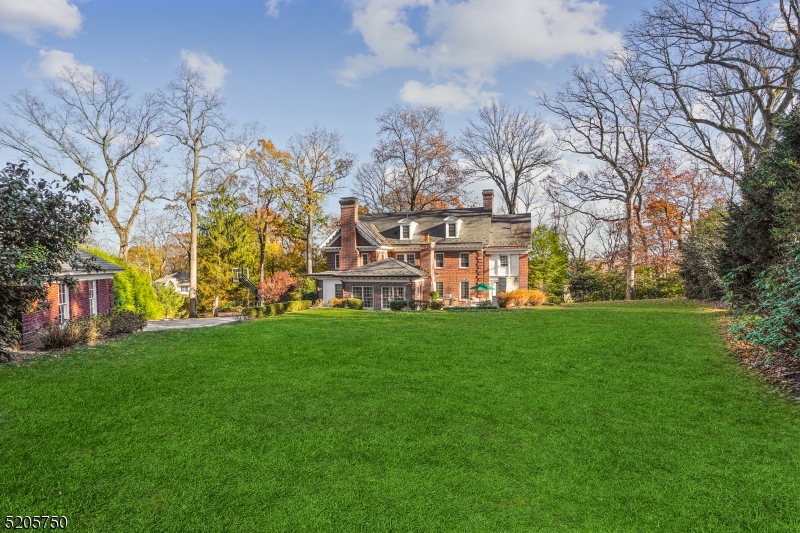 Stately Georgian Brick Colonial nestled in a private, picturesque setting within blocks of Summit's vibrant shopping, dining, public transportation, parks, and top-rated schools.  Layered in color and texture, this timeless 7 bed/4.2 bath home is ripe with historical architecture dating back to 1916.  The traditional construction with high ceilings and a spacious, versatile floorplan is enhanced by extraordinary millwork and beautifully refinished hardwood flooring throughout.  Formal living and dining areas are perfect for large gatherings and the winterization of the Sunroom allows for ample space for a dedicated Office or Den.  The classic charm has been preserved and enriched seamlessly through various additions providing flexibility for the needs of today's buyers, including Family and Mud rooms flowing from the kitchen and breakfast area, as well as a full J&J bathroom on the second floor.  The additional renovations of two full baths, a powder room, walk-in closets and basement transform the character of flawless architecture into modern traditional living.  Updated amenities make this magnificent home move-in ready, including 4 woodburning fireplaces, Marvin windows, slate roof, HVAC, and electric.  Built to accommodate entertaining as easily as everyday living, this home boasts over 6500 square feet and resides on an impressively landscaped yard with over an acre of land, an outdoor patio, fireplace, and extensive stonework.