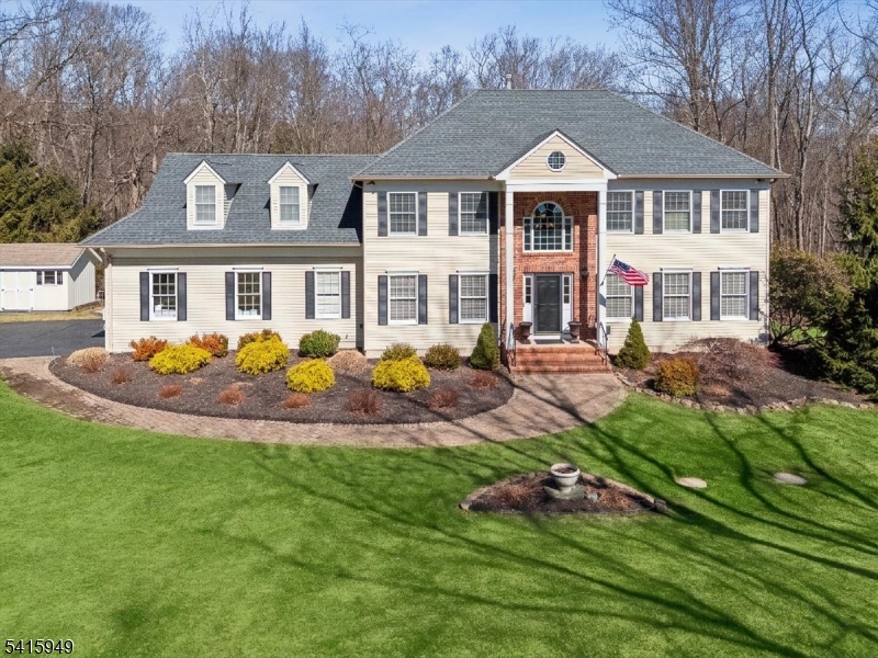 Tucked at the end of a quiet cul-de-sac in one of Chester Township's most desirable neighborhoods, this exceptional Colonial is set on 5+ private acres, offering a combination of elegance, privacy, and natural beauty. Rolling manicured lawns lead to a tranquil brook and a picturesque landscaped pond with a charming waterfall, creating a peaceful outdoor setting that feels like a private retreat. An expansive deck with an integrated gazebo provides the perfect space for outdoor dining, entertaining, or simply enjoying the serene surroundings.A welcoming 2-story foyer opens to a spacious formal living room and elegant dining room. The eat-in kitchen features granite countertops, a center island, and a bright breakfast area overlooking the scenic rear grounds w/direct access to the deck + gazebo. The adjoining family room showcases soaring cathedral ceilings and a wood-burning fireplace, creating a warm and inviting gathering space. A private office with a second fireplace, powder room, and laundry room complete the main level. Upstairs, the primary suite offers peaceful views of the wooded rear property, a spa-like bath + a spacious WIC. Additional beds provide generous accommodations. The  walk-out basement offers flexible space for recreation, fitness, or entertaining. This remarkable property presents a unique opportunity to enjoy exceptional comfort and privacy while remaining just minutes from Chester's charming downtown, boutique shopping, dining, and top-rated schools.