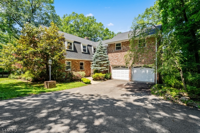Rarely does a home of this caliber come to market. Set on a quiet cul-de-sac in Watchung, this 6BR/4.5BA home offers over 4,000 sq ft (per tax records) of refined living space, park-like grounds, and a private tennis/pickleball court - all within an hr from Midtown Manhattan via NJ Transit. Imagine morning coffee on the deck as sunlight filters through the tree canopy. Cocktails by the fireplace in the family room (feat. wet bar). Weekend tennis matches steps from your back door. This is the lifestyle 60 Brook Drive delivers, every single day. The first floor features: formal living and dining rooms, a fireside kitchen & casual eating space that flows to the deck, family room, laundry and a full bath. The second floor has a primary suite with six closets, private balcony, and it's own full bath. Five other spacious bedrooms and two add'l full baths round out the second floor. Hardwood floors throughout. The finished lower level has a half bath & provides space for a gym, lounge, or recreation with sliders to the backyard. Two-car garage and add'l parking. Top-rated Watchung Hills Regional schools serve the district. The heavy lifting is done: approx. $200K in upgrades since 2021 including GAF Timberline roof, all windows replaced (Anderson), Bosch heat pumps (also provide cooling), Navien combo boiler, upgraded electrical panel, and well pump. Two owners in sixty-two years. One extraordinary home. So much more life to be lived in it.
