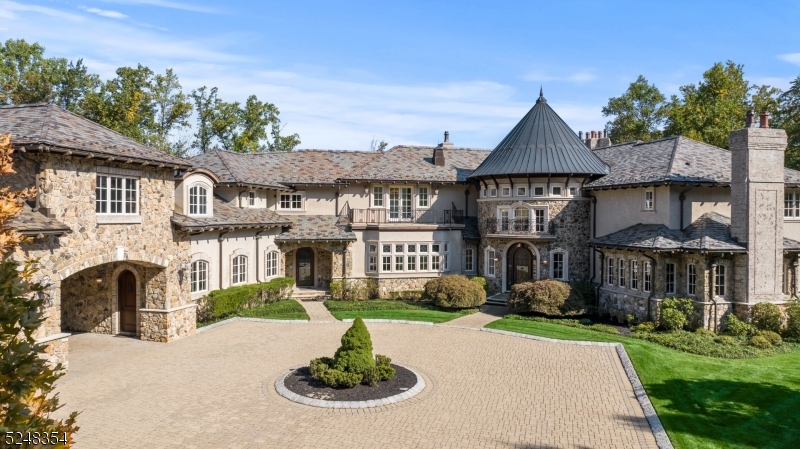 Welcome to this magnificent 10,000 sq ft masterpiece designed by renowned architects Beer & Coleman, nestled within the luxurious enclave of "The Pond. This private gated estate greets you through the portico and as you enter the grand foyer w/ dual staircases, your gaze will be captivated by the cathedral-stained glass dome designed by artist mark Bogenrief. The entire home is adorned with designer finishes, new hardwood floors, arched doorways, and soaring ceilings. Entertain with ease in the sprawling great room, complete with wet bar and access to the billiards room and wine library. The heart of the home, the kitchen, is adorned with dual islands, a custom-built pizza oven, barrel ceilings & sculpted granite countertops. Step outside into your own private paradise - the resort-like grounds boast a 2-hole golf course, stone terrace w/fireplace, and a covered kitchen. The 1,600 sq.ft executive center inc. 2 office suites, conf. room, kitchenette & bath taking working from home to another level. An elevator to all 3 floors makes this home an entertainer's paradise, offering unparalleled luxury, privacy, and sophistication in every detail.