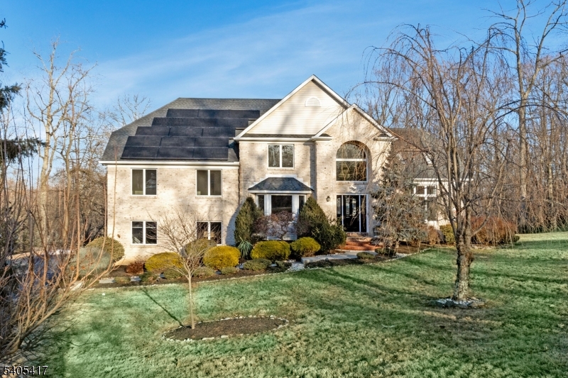 Set atop the highly sought-after Martinsville mountaintop section, this exceptional custom-built brick home offers privacy, elegance, and breathtaking views on 1.88 acres on a quiet cul-de-sac. An elongated blacktop driveway leads to a gracious front entry. Inside, a dramatic two-story marble foyer with sweeping staircase and arched doorways sets the tone for refined living. The formal living and family rooms feature soaring peak ceilings and custom French doors, perfect for both open flow and intimate gatherings. The expansive family room showcases a wood-burning fireplace, wall of windows, and seamless connection to the gourmet kitchen with granite island, five-burner range, walk-in pantry, separate dining area, and sliders to a deck with spectacular views. A Butler's pantry with wet bar provides elegant access to the formal dining room. The main level also includes a private office or bedroom, full bath, and laundry room. Upstairs, the primary suite impresses with a vaulted ceiling, walk-in closet, and spa-like bath featuring jetted tub, dual vanities, and skylight. Three additional bedrooms with an adjacent full bath are on an additional level. The finished walk-out lower level is ideal for entertaining with a custom bar, full bath, and separate heating. Energy-efficient upgrades include owned solar panels, new heat pumps, newer roof, and mechanicals. A rare offering of luxury, comfort, and value this home is truly not to be missed.