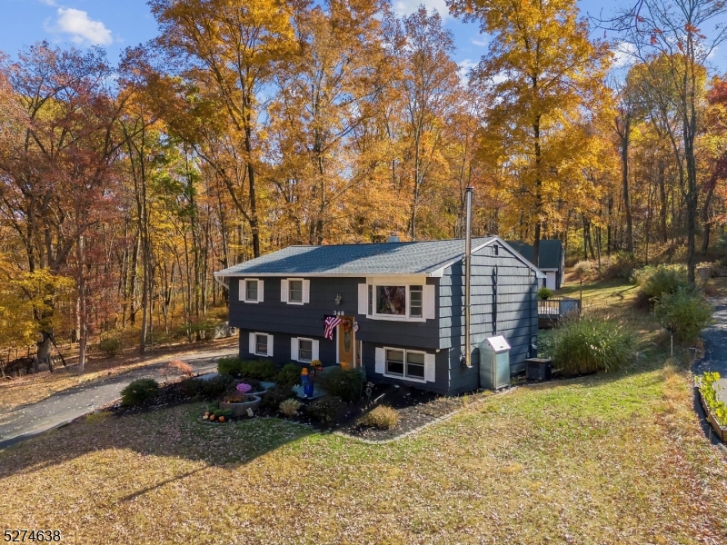 Welcome to this charming bilevel home nestled on a serene private lot approx. 1 acre. From the moment you step into the foyer you'll appreciate the care and attention that has gone into this home. The freshly painted interior and custom woodwork throughout the home creates a warm and inviting atmosphere. The kitchen, updated with granite countertops and SS appliances in 2022, opens to a formal dining room and living room with newly refinished blonde hardwood floors and a customized bay window 2022. There are sliders that open up onto 2 large beautiful decks. The updated main bath features built-in storage and granite countertops. 3 bedrooms on main level include the blonde hardwood floors with recessed lighting in master bedroom. Lower level boasts a family room with wood-burning stove, sliders to the spacious private park-like backyard, a full bath, a handcrafted oak office with built-in shelving and cedar closet, a mud room/laundry room with utility sink/one car garage. The extensive property also boasts a huge two-story 3-car detached garage with insulated doors, electricity, its own propane furnace and an upstairs workshop with loads of storage. Central air, thermal windows, whole house attic fan, custom molding throughout the house, newer roof 12/2019, wood shingle siding, beautiful landscaping and hardscape completes this delightful oasis. Conveniently located near shopping, great schools, and transportation, this home offers both modern amenities and serene privacy.