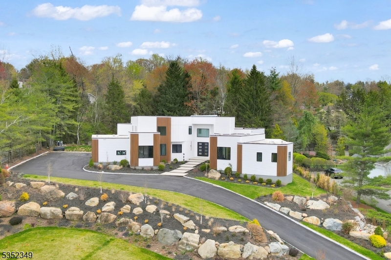 Welcome to this newly constructed, 9 Bed, 8.1 Ba, ONE OF A KIND contemporary home in the prestigious Chestnut Hill neighborhood offering approximately 13,000 sft of exquisitely crafted living space across three levels set on nearly AN ACRE of beautifully landscaped resort style private grounds with a sparkling POOL. Be wowed by a grand two-story foyer illuminated by a skylight, leading to a spacious family room with SOARING 20 FT CEILINGS. Elegant formal living and dining rooms open seamlessly to an expansive covered deck. The designer kitchen is outfitted with top-of-the-line WOLF & SUBZERO appliances, designer cabinetry, waterfall island, butler's pantry, and a large walk-in pantry. The spectacular primary suite is a true retreat, featuring a spa-inspired bath, dual designer walk-in closets, an attached yoga and meditation space with skylights, and a private office. Additional highlights include a dramatic statement staircase, custom built ins throughout, a four-car garage & a fully finished massive basement with nine-foot ceilings. This smart home is equipped with Ring, Nest thermostats & EV charger outlets, all ideally located near top-rated schools, Livingston's vibrant downtown, major highways, and premier shopping. This exceptional residence combines sophisticated design, luxurious amenities, and an unbeatable location to offer the ultimate living experience.
