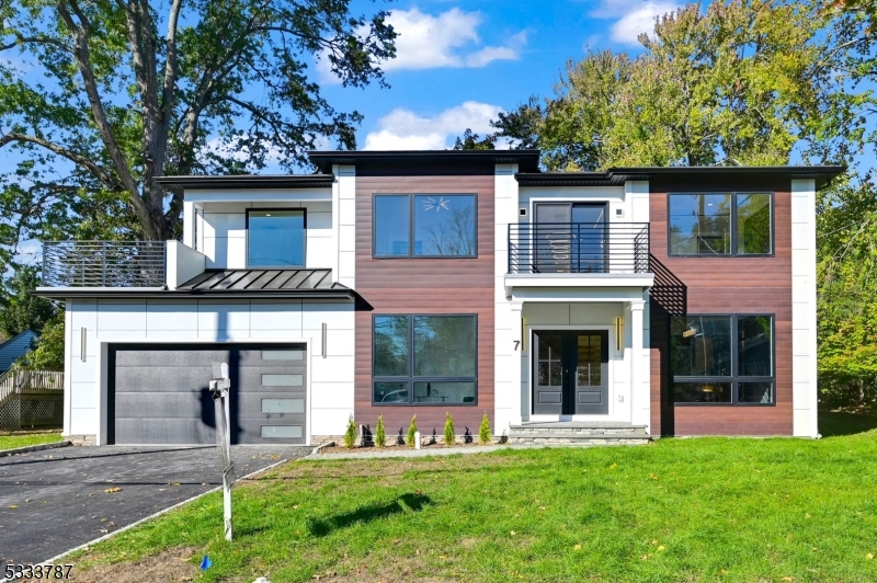 This gorgeous NEW CONSTRUCTION contemporary style Colonial has 4,700+/- sf of finished living space on 3 floors & has 6 BDs, 5.5 BAs. Smart home features include Nest thermostats, security cameras & EV charger outlet, hardwood oak floors and 8-9' ceilings throughout, custom moldings & trim work. The 1st floor is home to a formal Living Room, formal Dining Room, spacious Kitchen with walk-in Pantry, 1st floor en-suite, Family Room w electric fireplace & sliders to patio, Mudroom & Powder Room. The kitchen boasts natural & modern black & light oak floor-to-ceiling cabinetry, a large island w a one-sided waterfall countertop, quartz counters & JennAir stainless steel appliances. The 2nd floor houses 4 BDs, 3 Full BAs & Laundry including the Primary Suite w electric fireplace, enormous walk-in closet & spa-like Primary Bath w soaking tub & stall shower w dual shower heads & wrap-around balcony overlooking the front & lush rear yard, add'l Bed w en-suite Bath, 2 add'l beds & full Bath. Full Finished walk-up basement w large Rec Room, Media Room w platform & media system, an office & a full Bath. 10-YEAR BUILDER'S WARRANTY