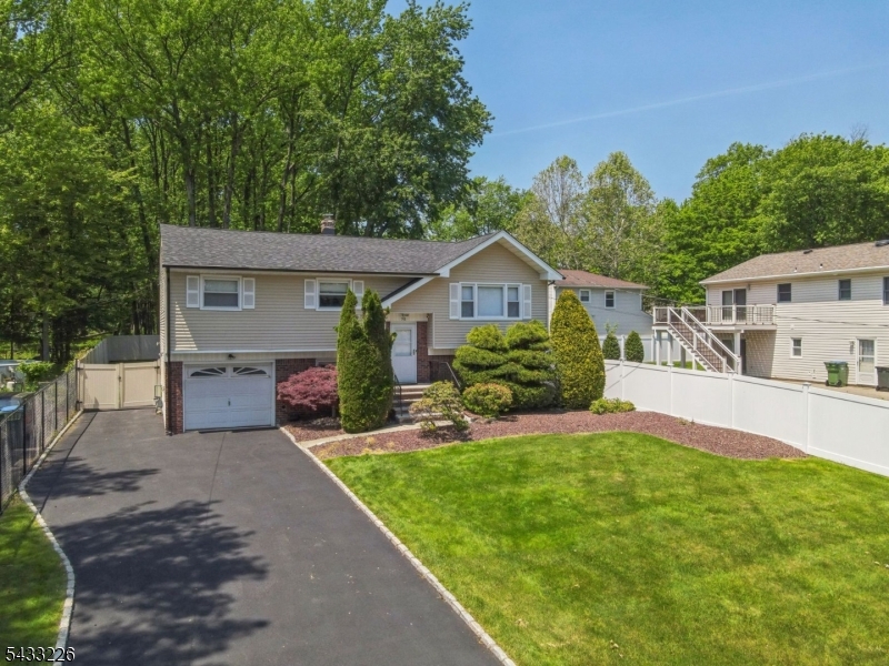 Welcome to this meticulously maintained, suburban oasis sitting on an extraordinary 0.52-acre prime lot in a highly desirable neighborhood in Edison with potential for development. Offering a perfect blend of space, functionality, and move-in ready comfort, this 5-bedroom, 2-bathroom split-level home is a rare find. The bright, open-concept main level features expansive living and dining spaces accented by beautifully polished hardwood floors. The kitchen opens directly via sliders to a massive, freshly stained deck, ideal for seamless indoor-outdoor entertaining overlooking your plush, fully fenced-in private backyard. The upper level boasts three spacious bedrooms, including a primary suite with direct bathroom access. The fully finished lower level offers incredible versatility, featuring a large fourth bedroom, a fifth room perfect for a private home office, a dedicated laundry/utility room, and direct access to the built-in garage. A second full bathroom is conveniently located off the spacious recreation room, which features sliders leading straight out to the sweeping yard. Complete with a brand-new roof and central heating/cooling, this home offers total peace of mind. Positioned on a rare, expansive lot bordered by peaceful woods, the property offers unmatched privacy today and incredible long-term investment potential for the future. Don't miss this rare opportunity.
