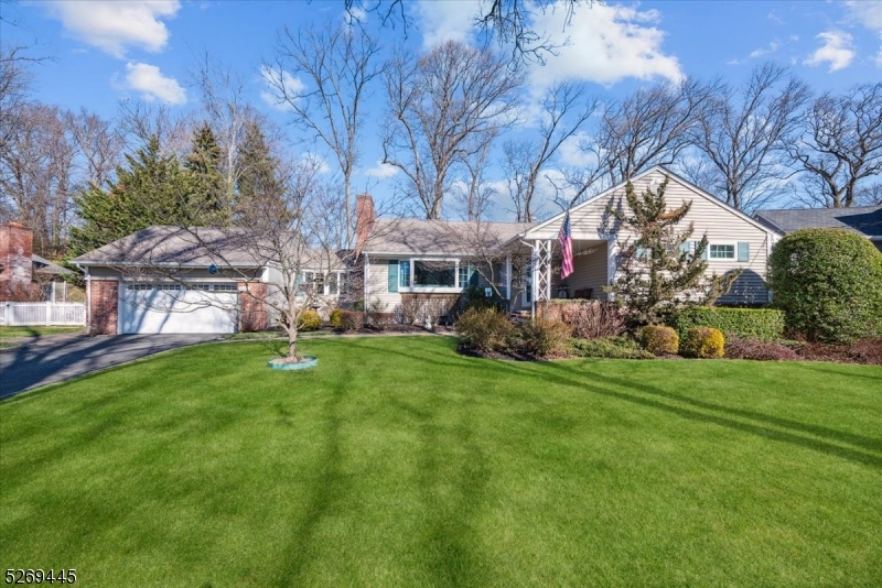 Move-In Ready Charm in a Premier Neighborhood! Well-maintained expanded ranch with 3 bedrooms and 2.5 baths in a fantastic residential neighborhood of Mountainside close to stores, restaurants and parks, plus convenient access to highways, NYC, and Newark Liberty Airport. A welcoming porch and entry lead into a spacious living room with a wide bay window and classic gas fireplace surrounded by brick. Just beyond is a spacious kitchen with rich wood cabinetry, black granite counters, stainless steel appliances, movable butcher-block center island, recessed lighting, dining area, and hardwood floors which can be found throughout the home under carpeting. A bright and sunny TV room/den is perfect for informal chats or reading a book, while a separate sunroom boasts walls of windows and peaceful backyard views. There are 3 bedrooms and a full updated bath with tub off the hall, including a generous primary with 2 closets and en-suite bath with shower. An attached 2-car garage off the TV room completes this level. The finished lower level has additional living space, housing a family room with built-ins, a huge rec room with wet bar, a half bath, laundry, utilities, storage, and stairs leading to exterior Bilco doors. Warm weather entertaining awaits in the fully fenced yard with stone patio off the sunroom and storage shed, offering lots of space for relaxing, gardening or playing games. Nothing to do but unpack and enjoy!