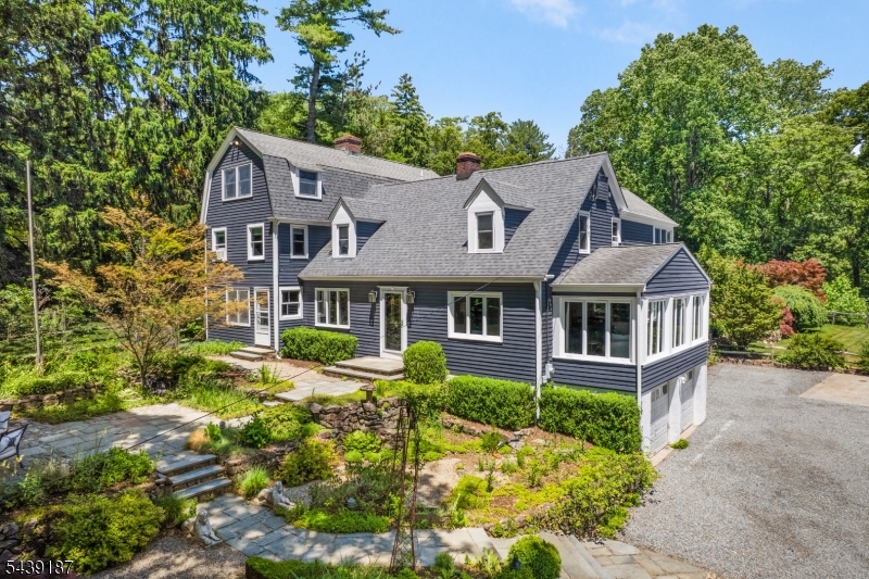 Set on 1.25 picturesque acres on the desirable east side of Mendham Township, this home offers a rare combination of privacy, character & natural beauty. A spectacular living room surrounded by walls of windows showcases seasonal mountain views, creating a stunning focal point & bringing the outdoors in year-round. Rich architectural details throughout the home include exposed brick accents, warm gathering spaces, & timeless finishes that blend character with modern comfort. The expansive custom kitchen features abundant cabinetry, a Viking range, a coffee bar & a sunny breakfast room, creating the perfect setting for casual mornings or formal entertaining. A first-floor room with adjacent full bath provide flexibility for guests or home office. The spacious primary suite serves as a peaceful retreat, complete with sitting room & an updated private bath. The finished third floor w/  exposed beams, offers exceptional bonus space ideal for a recreation room or home gym. Outside, resort-style amenities await. The heated Gunite pool is surrounded by expansive flagstone patios & beautifully landscaped grounds, creating an extraordinary setting for summer entertaining or quiet relaxation. Located in the sought after Brookside section of Mendham Twp, known for its highly rated schools & small-town charm! This special property offers the perfect balance of refined living & everyday convenience where timeless character, beautiful grounds, and an outstanding location come together.