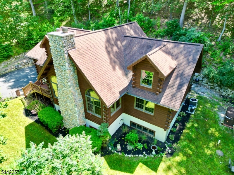 Looking for privacy and tranquility? Welcome Home to this absolutely stunning, well maintained, luxury Log Home on 5.63 acres. Soaring ceilings with oversized windows invite you to enjoy views of peaceful woods and seasonal skyline stretches. The combined kitchen/dining room, with double/prep sinks on the center island, opens to a screened-in porch for easy indoor/outdoor entertaining. Featuring four generous bedrooms, two on the first floor, including the primary suite as well as a flexible 5th room/office, and two more bedrooms upstairs, one ensuite. In-law suite potential if needed. The second floor loft, 23x13', offering many possibilities, overlooks the 22x17' living room and stone fireplace. A The huge ground level family room is a flexible space that could be used for hobbies, gaming and more; it includes a half bath and a storage room. An attached two car garage and extensive hardscaping round out this unusual offering. Close to routes 80 and 46 for easy commuting. Near to hiking, fishing, camping and more...but if you lived here you might not want to leave home because you can enjoy nature without stepping a foot off your own property.