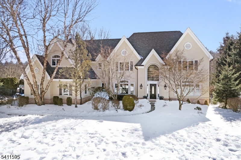 Situated on a private cul-de-sac, this stunning home delivers the perfect blend of timeless elegance & luxury. The chef's kitchen is the true heart of the home, anchored by a massive quartzite center island & outfitted with a 48 Wolf range, brand new bosch dishwasher, warming drawer, ice maker, temp controlled wine cellar, bar area, and sun-filled breakfast room. Custom inset cabinetry, thoughtfully designed pantry storage & a cozy sitting area w/ a sleek gas fireplace. The dramatic two-story fam room is a showstopper w/ soaring vaulted ceilings, intricate architectural millwork, a statement brick fireplace, sweeping rear staircase, & multiple French doors opening to the yard. Outside, your private resort awaits: a bluestone patio, wood-burning fireplace, heated saltwater pool w/ cascading waterfalls, raised chef's garden, covered lounge area & manicured lawn. Car enthusiasts & organizers will appreciate the 3 car garage makeover w/ custom cabinetry & extensive storage solutions w/ new epoxy flooring. Home also features a 1st floor office, designer mudroom, copper gutters, metal roof & 2 updated HVAC systems! The luxurious primary suite features a tray coffered ceiling, walk-in closets w/ custom built-ins and a spa-inspired bath w/ luxe shower, tub & heated floors. 3 additional BR's w/ custom closets, 2 full baths & a convenient laundry room complete the SL. The finished LL offers exceptional bonus space w/ a large recreation room, full bath, gym & a speakeasy-style pub.