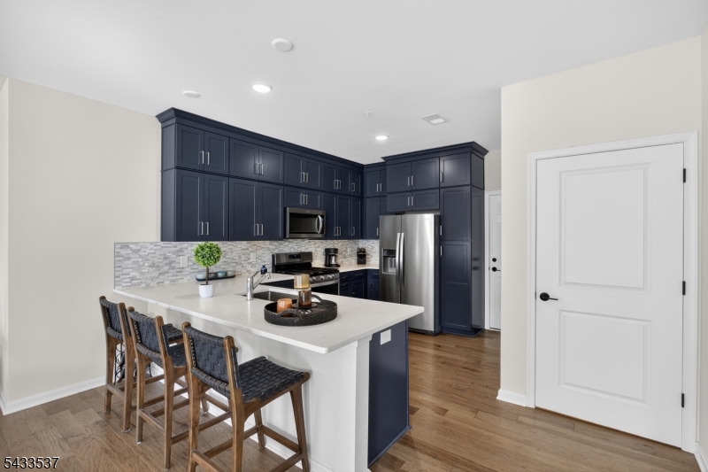 Discover modern living in this beautifully upgraded 2 bedroom, 3 full bathroom townhome located in the highly desirable Townhomes at Vermella. Featuring approximately 1,238 sq ft, this functional floor plan offers bright, open living spaces designed for both comfort and style. The heart of the home is the stunning designer kitchen showcasing stacked Sonoma navy cabinetry extending to the ceiling, Quartz Carrara Marmi countertops, and a timeless Carrara tile backsplash. The open-concept layout flows effortlessly into the dining and living areas, creating the perfect setting for entertaining or everyday living. Recessed lighting throughout enhances the home's clean and modern feel. A standout feature is the rare three full bathroom layout, offering added flexibility for guests, and work from home living. The spacious primary suite includes a private en-suite bath and a custom walk-in closet complete with built in organization systems. Residents enjoy access to Vermella's premium lifestyle amenities, including a resort-style pool, fitness center, clubhouse, and landscaped common areas. Conveniently located near shopping, dining, major highways, and NYC transportation, including a nearby train station. A rare opportunity to own a thoughtfully upgraded home in one of the area's most desirable communities.