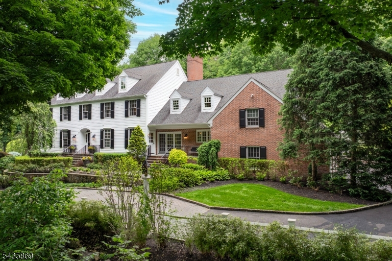 A private, landscaped drive winds through the property, setting the tone for this exceptional hillside estate. Inspired by classic Williamsburg architecture and beautifully reimagined with a newly refinished interior by Frank DelleDonne, the home blends timeless design with modern comfort. Six bedrooms are thoughtfully arranged throughout, including three en-suite retreats. The third floor offers three additional bedrooms served by a charming locker room-inspired bath. A flexible floor plan accommodates a variety of lifestyles, including a separate guest suite or private office wing. At the heart of the home, the kitchen opens seamlessly to a spectacular breakfast/family room featuring a soaring cathedral ceiling, fireplace, and dramatic wall of windows. Additional gathering spaces include a media room/den and a dining room with built-in banquet seating and wet bar. The walk-out lower level is designed for entertaining and relaxation with direct access to a terrace with fire pit. Outside, specimen trees, ornamental plantings and bluestone pathways enhance the grounds. The heated pool, spa, expansive sun deck, and pool house with full bath and kitchenette create a private resort-like setting. An outdoor kitchen overlooks the property and seasonal Ramapo Mountain views. Located in the highly regarded Mountain Lakes school district, Boonton Township offers parks, trails, golf courses, shopping, dining, and convenient access to major highways, NJ Transit, and New York City.