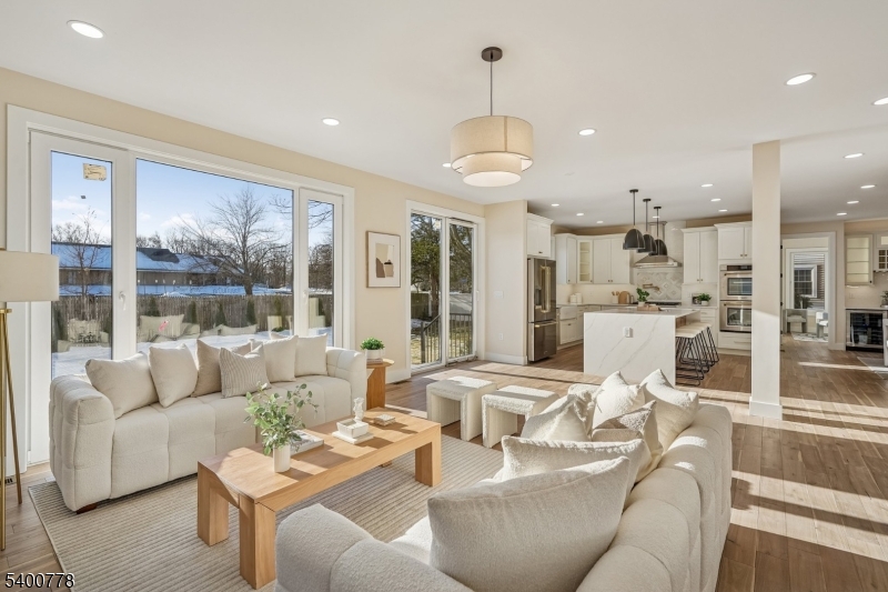 A striking statement of modern luxury, this extraordinary custom-built Colonial on existing foundation in Westfield showcases exceptional craftsmanship, refined architectural detail, and a thoughtfully designed open layout filled with natural light. Dramatic windows, custom millwork, and rich hardwood floors create a sophisticated yet inviting atmosphere throughout. The chef's kitchen serves as the heart of the home with quartz countertops, an expansive island, bespoke cabinetry, and top-tier appliances including a 6-burner stove and pot filler, flowing seamlessly into the family room with electric fireplace and access to the private backyard and patio. The first floor offers a private office, guest suite with full bath, formal living and dining rooms with built-in bar, powder room, and mudroom. The second level features a stunning primary suite with balcony, fireplace, custom walk-in closet, and spa-like bath, along with a princess suite, two additional bedrooms, two full baths, and laundry. A third-floor retreat and finished walk-out basement provide additional living space. Outfitted with tankless hot water and Cat 6 wiring, and ideally located near downtown, top-rated schools, and NYC transportation.