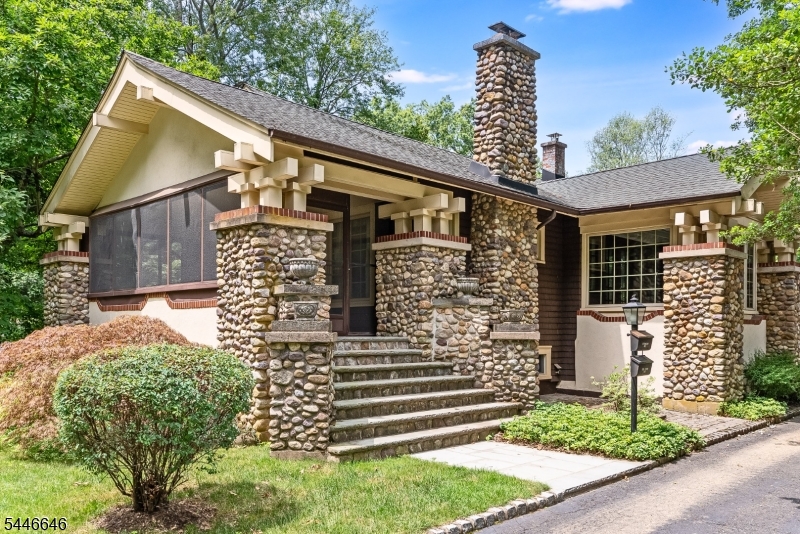 Set on over 1.7 private acres in Convent Station, this authentic Craftsman-style property offers timeless architectural character, a separate 1058 sq ft guest house and direct access to the natural beauty of Loantaka Park.  The three bedroom main house showcases the warmth and workmanship that define the Craftsman style with rich woodwork, authentic style hinged windows, glass-front cabinetry, hardwood floors, river-rock stone columns and a wood-burning fireplace with a brick and stone hearth. A screened porch overlooks the wooded front setting while the formal dining room opens to a bright sun porch with large picture window framing peaceful woodland views. The one bedroom guest house features its own utilities and laundry, along with a full kitchen, family room with a wood-burning fireplace, private deck, second-floor bedroom, and full bath offering exceptional flexibility for a variety of uses. Outside, enjoy a level large, private rear yard, a four-car detached garage, and a setting that borders Morris County's Loantaka Park with miles of trails for walking, hiking, cycling, horseback riding, and year-round enjoyment of the outdoors.  A rare opportunity to own a character-filled Craftsman property in an exceptional parkside setting.  Public water and sewer, central air in main house and split systems in guest house.  Truly spectacular!