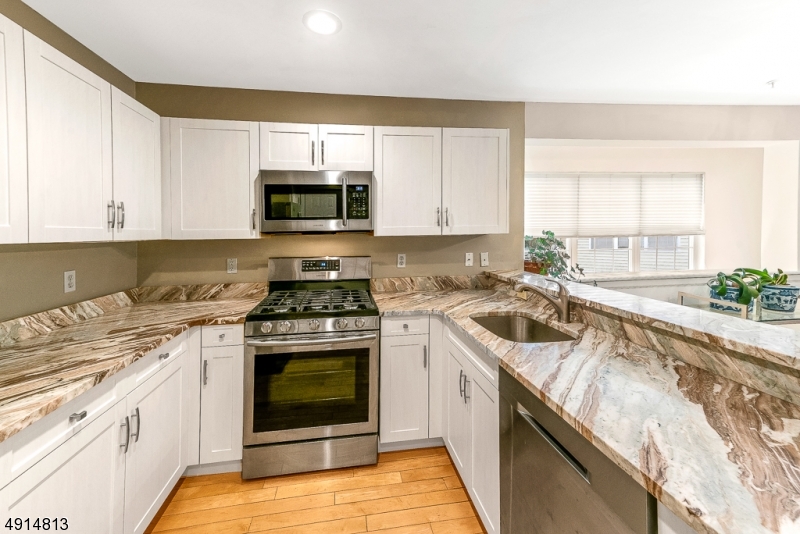 RARE FIND! ONE OF THE LARGEST MODEL END UNIT LOCATED IN DESIRABLE ALLWOOD MEWS. ALMOST 1600 SQ FT OFFERS VAULTED CEILINGS, SKYLIGHTS & LIGHT, BRIGHT & NEUTRAL. LOTS OF UPGRADES. COMPLETELY RENOVATED KITCHEN W/NEW GRANITE, S/S APPLIANCES, FIXTURES & CABINETRY. THIS EAT IN KITCHEN  OFFERS LARGE BREAKFAST BAR PROVIDING PLENTY OF COUNTER SPACE. THE OPEN FLOOR PLAN IS PERFECT FOR ENTERTAINING. LIV RM FEATURES GAS FIREPLACE, H/W FLOORING.  FIRST FLOOR BEDRM/OFFICE W/SLIDERS TO PRIVATE DECK. MASTER BDRM W/WALK-IN CLOSET & FULL BATH. 2ND BDRM W/FULL BATH. CENTRAL A/C, ATTACHED GARAGE W/STORAGE AREA. COMPLEX IS CLOSE TO PUBLIC TRANSPORTATION A SELF CONTAINED DEVELOPMENT IN SECURE AREA. ROOF ASSESSMENT $70.00 PER MONTH TO BE ASSUMED BY BUYER