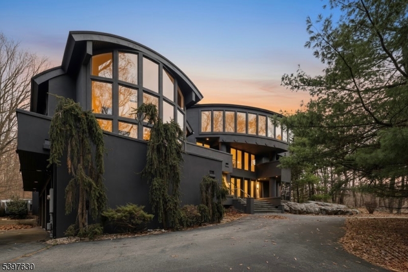 Welcome to this striking, fully-renovated modern masterpiece set on over 3 private acres in the prestigious, gated Smoke Rise community. This one-of-a-kind contemporary residence delivers more than 6,000 sq ft of architectural luxury. Designed to impress from every angle, the home blends bold modern lines with warm, sensual materials, creating an atmosphere that feels both sophisticated and effortlessly alluring. The dramatic entry opens to a soaring two-story living area, wrapped in glass and anchored by architectural sight-lines that flood the home with natural light. The expansive great room features a stunning wall of windows and a sculptural barrel ceiling an entertainer's dream space that feels as breathtaking at dusk as it does at dawn. The entire second level is a private primary sanctuary, a full-floor retreat floating above the main living spaces. A gallery corridor overlooks the dramatic rooms below and leads to a sumptuous primary suite complete with a spacious spa bath, custom closet, intimate sitting area, and a series of private balconies and terraces that surround the home offering serene views in every direction. A bonus walk-up attic was conveniently converted to the perfect guest suite. The main level also provides incredible flexibility with 3 bedrooms, 2 full baths, generous storage, and a sleek 3-car garage. Every space is thoughtfully designed, blending functionality with high-end finishes and a distinct sense of style.