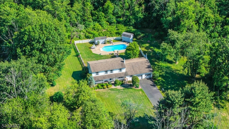 Tucked away on a picturesque, private wooded lot, this beautiful 4-bedroom, 2.5-bath Colonial offers the perfect blend of space, comfort, and serenity. Designed for both everyday living and effortless entertaining, the standout feature is the spectacular 32-foot family room complete with a built-in bar and expansive windows that showcase breathtaking views of the resort-style backyard.Step outside to your own private oasis featuring a sparkling in-ground pool, lush landscaping, and tremendous privacy ideal for relaxing summer days and memorable gatherings. The main level offers a welcoming layout with spacious living areas, a convenient powder room, and excellent flow throughout.Upstairs, you'll find generously sized bedrooms, including a spacious primary suite designed for comfort and relaxation. Surrounded by nature yet offering all the space you need, this exceptional home provides a peaceful retreat while remaining perfect for entertaining. A rare opportunity to own a truly special property where privacy, charm, and outdoor living come together beautifully.