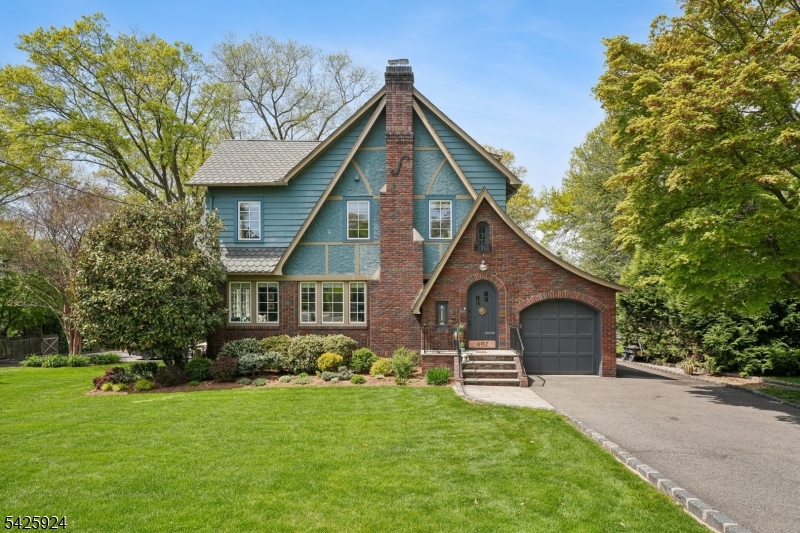 Welcome to your private, resort-style oasis just minutes from Manhattan. Artfully reimagined and steps from both Maplewood and South Orange downtowns, this sun-bathed Tudor is a one-of-a-kind sanctuary combining historic soul with chic design and breathtaking South Mountain views. The 1st level balances warmth and function with effortless style. A sunlit living room with WBF flows into a dining space and family room, both with access to a picturesque covered porch - perfect for morning coffee and sunsets. The chef's EIK anchors daily life, featuring custom cabinetry, soapstone counters, new smart/premium appliances, Vulcan stove, coffee bar, and walk-in pantry. A convenient powder room, mudroom, and garage entrance complete this level. Multiple living areas, including a finished basement with media space, wet bar, and large laundry room, offer flexibility for entertaining and everyday living. Upstairs features three generous BRs with ample closets, Jack-n-Jill bath, and private primary en-suite. The 3rd level offers a 4th BR/office plus a separate lounge and yoga space. The backyard is a true showstopper: a luxury, multi-level retreat centered around a smart-enabled, heated saltwater pool and a wrap-around deck with dedicated BBQ, dining, and lounging areas. Beyond the pool, a professionally landscaped garden with fire pit creates a rare sense of privacy. Designed not just to live in, but to escape to every day.