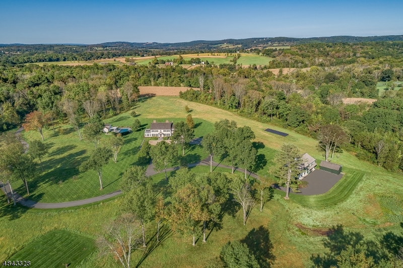 Hidden Holly Farm is a magnificent compound set on 33.5 acres of vast meadows. Completed in 2009, the estate has the look of a historic farmstead while embracing todays most luxurious appointments. The long meandering drive passes a private helipad and barns as you arrive at the 16 room main residence. Beautifully scaled, finely detailed rooms feature exquisite wide-plank cherry floors, layered crown molding; French doors, wood-burning fireplaces and en-suite bedrooms. Outside is the custom pool; pool house with kitchenette & full bath; independent spa & covered verandas with sweeping views. English garden inspired landscape. This country compound also includes a barn with 2 bedroom guest apt, 4 large bays & add'l storage barn. Generator. Convenient to the train, major highways, shopping & restaurants.