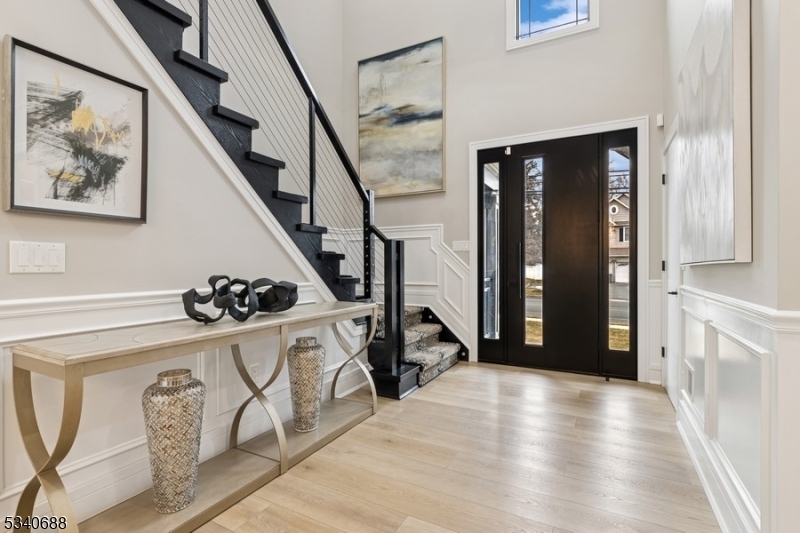 Stunningly renovated Colonial style home offers five bedrooms, four-and-a-half bathrooms, and an attached one-car garage. Situated on a manicured lot with a back yard pool, this home is close to schools, shopping, dining, parks, and the train station to New York City.A wide driveway for extra parking takes you inside to a two-story foyer revealing a magnificent interior perfect for entertaining. Distinctive features include hardwood floors, an open floor plan, elegant crown molding, large windows for abundant natural light, coffered ceilings, and modern luxury finishes throughout. The sleek and stylish chef's kitchen is equipped with quartz counters, custom cabinetry, high-end appliances, and a waterfall countertop island with seating. The open flow continues to the large living room with a coffered ceiling and a gas fireplace adjacent to the banquet-sized dining room ideal for dinner parties. Throw open the sliding glass doors to relax or entertain on the patio surrounding the serene in-ground swimming pool. Completing the main level is a convenient laundry room, a bonus room, and a powder bathroom.The second floor includes the primary bedroom suite with two walk-in closets, and a luxurious en suite bathroom with a pedestal tub and an oversized glass shower. There are four additional bedrooms, one with an en suite bathroom, and a hallway bathroom. The finished basement offers a huge recreation room, a glass-enclosed exercise room, a full bathroom, and plenty of storage.