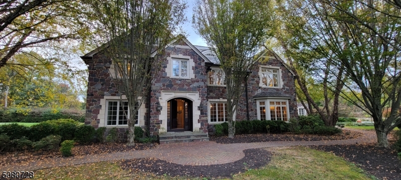 Experience the charm of country living as you drive down the picturesque lane leading to this stunning stone manor, nestled on one of the most prestigious streets in New Vernon. With its elegant slate roof and beautifully divided light windows, this home epitomizes perfection.Step inside to discover captivating living spaces designed for modern lifestyles, featuring unparalleled attention to detail. Enjoy multiple office areas and gathering spaces, allowing everyone to spread out in style. French doors seamlessly connect the indoor and outdoor spaces, enhancing the flow of your entertaining.Each bedroom boasts an ensuite bath, thoughtfully designed for comfort and convenience. The magnificent lower level is a true oasis, complete with a home cinema, an exercise and yoga room with an adjacent full bath and sauna, and a spacious kitchen and family room perfect for gatherings.The lush, landscaped grounds feature charming French-inspired stone patios that overlook a beautiful lawn. For golf enthusiasts, a turf putting green with two sand traps and three chipping boxes provides the perfect opportunity to hone your skills.Set on a level, usable three acres on a serene street in New Vernon, this home offers countless opportunities for entertaining and enjoying the tranquility of your surroundings. Don't miss your chance to make this exceptional property your own!