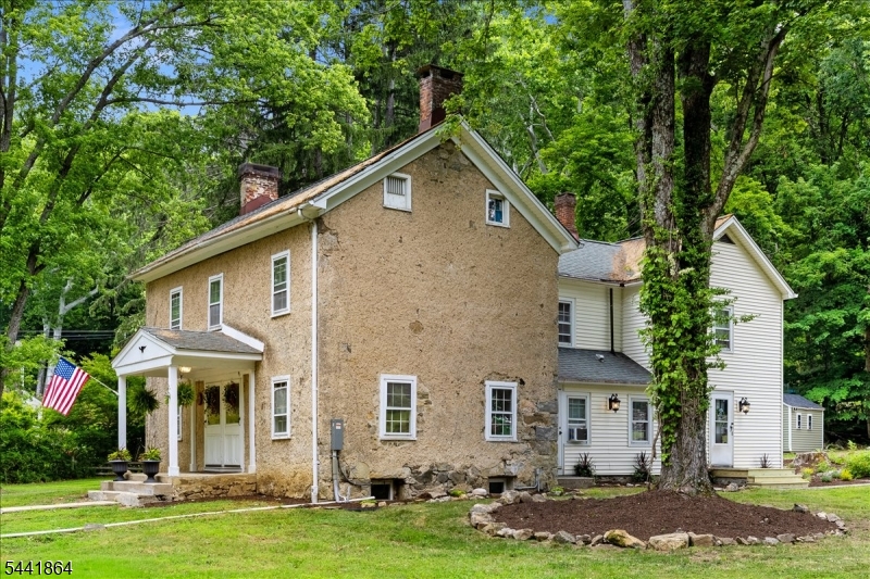 Steeped in history, this magnificent 1830's stone Colonial offers a rare blend of historic character, modern amenities, and serene rural living. Tucked back from the road on 6.79 sprawling, landscaped acres, the property boasts approx. 800 feet of pristine river frontage. Imagine spending your evenings sitting by the fire pit right at the edge of the water; your own private haven for kayaking, fishing, or relaxing. Inside, the home features magnificent, original wide-board Pumpkin Pine floors through many of the rooms. The main level with entertaining spaces and cozy retreat spaces, including a oversized living room anchored by a stately stone fireplace, a formal dining room, and a large eat-in kitchen. A smaller family room offers the perfect quiet reading nook, 4 bedrooms and 2 full baths; plenty of room for everyone. The primary suite features its own private sitting area, a large closet, and an updated en suite bath. While the home honors its 1830's roots, it embraces the future with incredible energy efficiency. Equipped with an efficient pellet stove and an owned solar panel system, the new owner will inherit the ultimate luxury: low to no heat or electric bills, and make money selling the SREC's. This is a legacy property offering privacy, timeless architecture, modern self-sufficiency, and a front-row seat to nature's beauty. Great commuting location just minutes to Routes 31 & 78. Near to shopping & Lebanon Twp's great schools & parks.