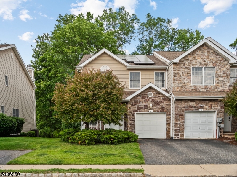 Welcome to this spacious end-unit townhome located in the highly desirable Mazdabrook community of Parsippany. This Sycamore model is the largest in the community, and stands out with extra living space, privacy, and a fully finished basement with an added full bathroom. The main level features abundant natural light, hardwood floors, a wood-burning fireplace, and sliding doors that lead to a private walkout deck. The kitchen features recently upgraded appliances, a new fridge, and a peninsula offering extra counter space. The second level boasts new hardwood floors throughout, and three large bedrooms, anchored by a primary suite complete with an en-suite bathroom, walk-in closet, and abundant storage. The fully finished basement truly sets this home apart, with an added full bathroom, offering ample additional living space ideal for a home office, gym, or recreation area.  Additional highlights include an installed central vacuum and water softener system, an attached one-car garage, a two-car driveway with guest parking nearby, and low HOA fees. Recent upgrades include a new roof (2025), included solar panels, and a new tankless water heater. Located just minutes from Routes 46, 80, 287,10, and with easy access to NYC-bound public transportation, this home offers the perfect balance of space, modern upgrades, and everyday convenience.