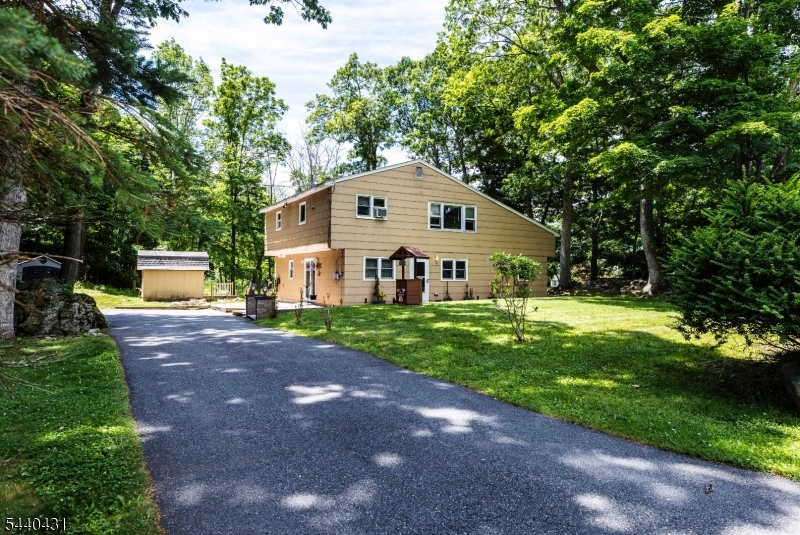 Welcome to this spacious custom home located in a quiet neighborhood near the sought-after amenities of Lake Hopatcong living. This four-bedroom, two-bath home offers an open-concept design and an airy feel that today's buyers will love.  As you enter, you'll be greeted by a large recreation room featuring custom tile flooring and a cozy wood-burning fireplace. This level also includes two generously sized bedrooms, full updated bathroom, laundry room and a leisure room with wet bar, making it ideal for everyday living, entertaining, or potential mother-daughter accommodations.  Upstairs, you'll find an open-concept kitchen and dining area complete with a large breakfast bar, new stainless steel appliances, double ovens, updated backsplash, and newer flooring. The updated main bath is conveniently located near two additional spacious bedrooms, including the oversized primary bedroom, which features a huge walk-in closet.  Step outside to enjoy the flat backyard and beautiful Trex deck, perfect for relaxing or hosting gatherings. With its versatile layout, generous living space, and desirable location, this home is one you won't want to miss!