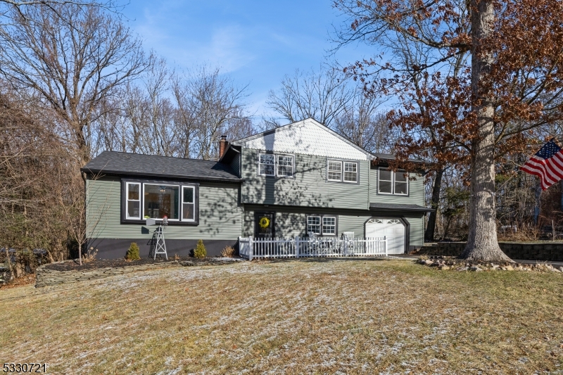 Move right into this stunning 4-BR, 2-BA split-level home with a 1-car garage, set on a private lot less than 5 miles from Greenwood Lake. Extensively renovated from 2020-2024, this home blends modern upgrades with timeless charm and a functional layout. The lower level welcomes you with a foyer, coat closet, pantry, and a family room featuring a spacious bar area, cozy wood-burning stove,a updated full bath, brand-new sliders to the patio, and direct access to the garage.  The main level boasts a bright LR, DR, and remodeled kitchen with wood-look tile floors, SS appliances, cathedral ceiling, skylight, and sliders to a 21' x 11' screened-in deck (2024) overlooking the private backyard ? perfect for bug-free outdoor living.  The 2nd floor includes all 4 BRs with updated lighting, new hardwood floors, and an updated main bath featuring vaulted ceilings, skylight, and double sinks. The large primary BR stands out with floor-to-ceiling hardwood floors and an electric fireplace for a cozy feel.  The finished basement offers a versatile rec room with recessed lighting, currently used as an office, next to the laundry/utility room. Key updates: new roof (2020), septic for 3 BR (2020), paved driveway (2023), front door (2024), gutters (2024), front siding (2024), and updated baths (2024). Conveniently located .2 miles away from Elementary school, 1 mile from ShopRite and near NYC transportation, this home offers both privacy and convenience. Schedule your showing today!