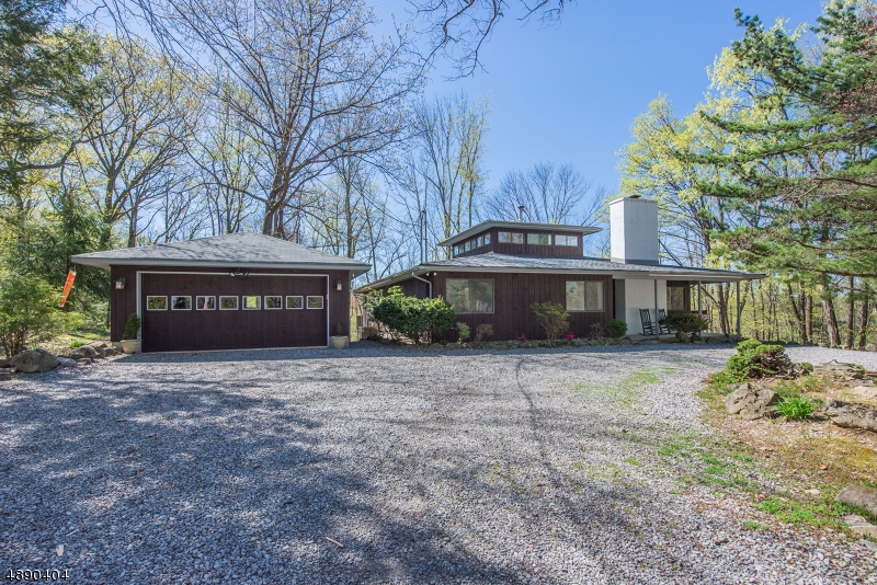 Your own private retreat awaits you on this beautiful one of a kind property. This modern 3 Bedroom home is nestled among the trees on 4 idyllic acres. New bonus room in basement and new roof 2019. This Mid-Century Modern home is styled using clean simplicity while integrating with nature. Ample windows, open floor plan, and cathedral ceilings provide lots of natural light. Enter the tall atrium featuring central wood stove. Kitchen is open to adjacent greenhouse room and family room with masonry fireplace. Entertain guests in the formal dining room and living room, sliders lead out to the expansive deck with amazing views. Large master suite with walk in closet. Second floor open loft used as spacious Den/office. Ground level with walk out and new bonus room featuring sliding barn door and radiant heat.
