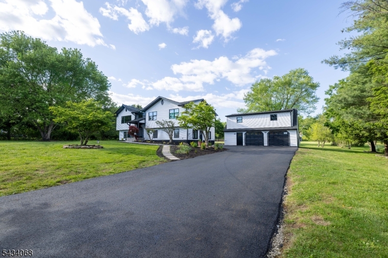 A rare opportunity to own a completely transformed estate-style home in historic Branchburg Township. Set on over 2 private acres, this exceptional property offers more than 3,600 sq ft of fully renovated living space with premium finishes throughout. The striking modern farmhouse exterior features crisp white siding with black roof and trim accents. Inside, enjoy soaring vaulted ceilings and an open-concept layout filled with natural light, recessed LED lighting, wide-plank flooring, and oversized windows with beautiful property views.The gourmet chef's kitchen features custom white shaker cabinetry, waterfall quartz island with seating, stainless steel appliances, custom hood vent, and designer lighting. A separate first-floor kitchenette adds flexibility for living or guest accommodations. The home offers 4 spacious bedrooms and 3 fully renovated bathrooms, including a luxurious primary suite with Jacuzzi soaking tub and designer shower system. Above the 2-car garage is a finished bonus suite with half bath, ideal for an office, gym, guest space, or entertainment room, with plumbing ready for a future full bath. Major upgrades include new roof, siding, windows, doors, septic system, well filtration system, 2-zone HVAC, and tankless water heater, low taxes. Enjoy the expansive deck overlooking open green space and a fully updated gas-heated in-ground pool with new liner and mechanical systems.  Schedule your private showing today.