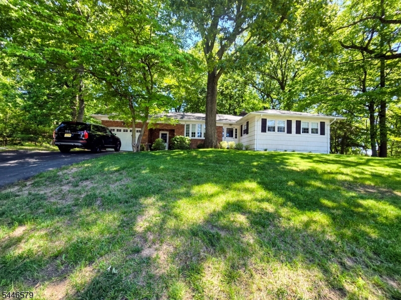 Investor Opportunity or Renovation Gem! Bring your vision to this charming ranch-style home brimming with potential in a private, semi-wooded setting. Original hardwood floors, a bright and airy living room with a brick, wood-burning fireplace, and an inviting flow into the dining area create the perfect foundation for your dream renovation.  The versatile floor plan features three bedrooms, three full baths, a cozy den with built-in cabinetry, a finished basement with vintage bar, workshop, an attached garage, and a spacious deck overlooking the lovely wooded backyard. Tucked away at the end of a residential street, this home offers exceptional privacy while remaining just minutes from major highways, shopping, restaurants, and NJ Transit for an easy commute.  Whether you're an investor, contractor, or buyer eager to personalize a home and build instant equity, this is an outstanding opportunity in a highly desirable location. Sold strictly As-Is.