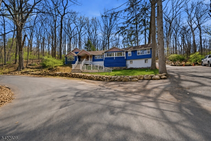 Charming Expanded Log Cabin in Lake Mohawk Country Club. Renovated in 2023 and freshly painted, this 4BR, 3BA home sits on 1.5+ private wooded acres in one of Sparta's most desirable lake communities. Inside, enjoy soaring wood-beamed ceilings, rich log walls, and a cozy stone fireplace that highlights the home's rustic character. The updated kitchen features modern appliances, ample counter space, and warm wood cabinetry. A spacious primary suite with en-suite bath offers a private retreat, while three additional bedrooms provide flexibility for guests, loved ones, or a home office.Major updates include a new roof and new HVAC for added peace of mind. The home offers plenty of room to entertain with spacious living areas inside and seamless access to outdoor spaces. Outside, enjoy a large driveway, paver patio, and expansive wooded property perfect for gatherings, outdoor dining, or relaxing in nature.Located in Lake Mohawk, membership provides access to private beaches, boating, fishing, and the iconic boardwalk with dining, shops, and year-round events. A rare opportunity to own a character-filled home with modern updates in a premier Lake Mohawk location.