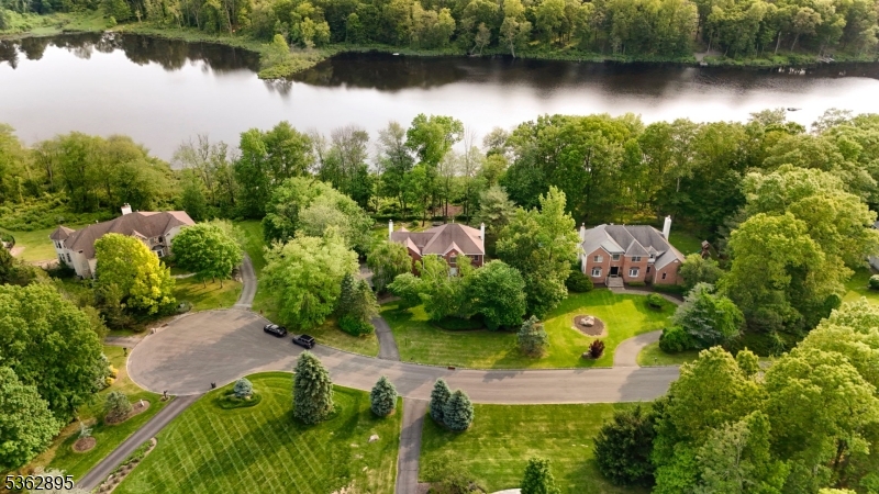 This stunning lakefront Colonial located on a quiet cul-de-sac in desirable Sparta Township offers luxurious living with breathtaking lake views from nearly every room and the rare advantage of a private dock for enjoying the lake lifestyle. Featuring hardwood flooring throughout, the home includes two master bedroom suites with built-in closet cabinetry, while the spacious primary suite boasts tray ceilings and leads to a spa-like bathroom with a jetted tub, shower with power sprays, and double vanities. The sun-filled family room is filled with natural light and showcases beautiful lake views, while the chef's kitchen is a dream complete with a Viking stove, newer refrigerator, and stainless steel appliances. The walkout basement provides additional living space including an exercise room, bedroom with a full bath, sauna, and potential for an in-law suite. Outside, enjoy the beautifully lit exterior, a fenced backyard, and a private dock perfect for boating, fishing, swimming, and relaxing on the water, all set within the privacy of a peaceful cul-de-sac location. With public water service and every detail thoughtfully designed, this home combines comfort, elegance, and the beauty of lakefront living while offering easy access to Sparta's top-rated schools, shopping, highly reviewed restaurants, and a wide variety of local activities.