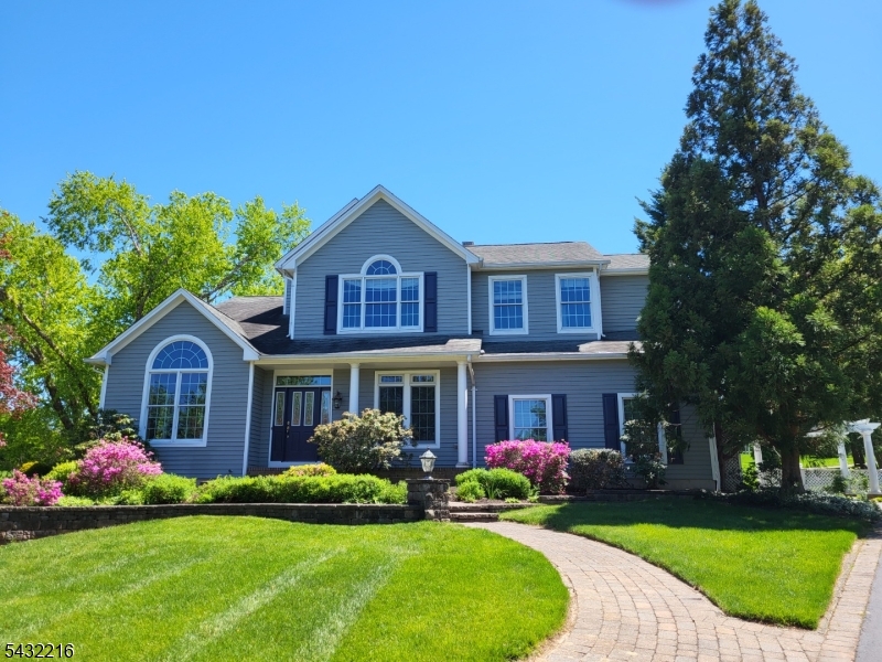 This bright 5-bedroom, 3.5-bath colonial in Cherry Valley sits on a professionally landscaped premium lot at the end of a quiet cul-de-sac, surrounded by mature trees for privacy and scenic views. The first floor offers an open floor plan with 10-foot ceilings, walls of windows, an in-law suite with a full bath, a private office, and a powder room. The kitchen features Corian countertops and island, tiled backsplash, 42-inch cabinetry, and a quiet Miele dishwasher. Upstairs, the primary suite boasts a cathedral ceiling and a walk-in closet with custom dressers and shelving. Three additional bedrooms, each with wall-controlled ceiling fans and lights, share a full bath with a double-sink vanity. A second-floor laundry area with washer and dryer adds everyday convenience. The semi-finished basement includes upgraded 8'8" ceilings, an art/craft room with utility sink and built-in cabinetry, a large home gym area with equipment, and a handyman workbench. The backyard, which is adjacent to community open space and trail, includes a large screened porch, two-level deck with 240V outlet for a hot tub, paver patios, 11' x 6' storage shed, and an 8-zone irrigation system. Located in the highly regarded Montgomery Township school district, the home also offers optional membership to Cherry Valley Country Club for golf, tennis, and swimming. Sale includes all indoor and outdoor furniture, TVs, gym equipment removal available upon request