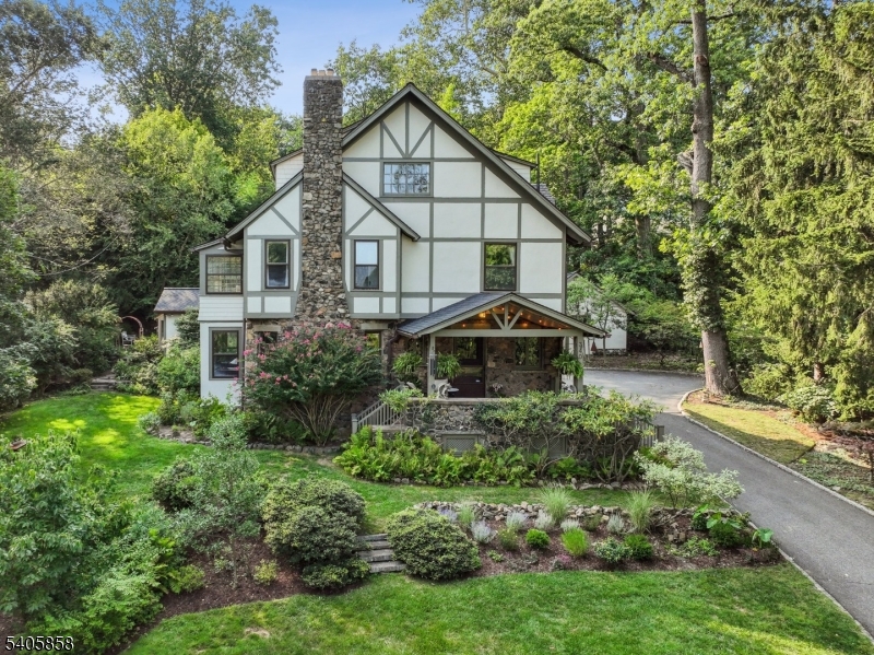 Craftsman Soul. Modern Ease. A Hidden Retreat in the Heart of Upper Montclair. Perched on nearly half an acre and tucked just enough off the road to feel worlds away, this 1897 Craftsman blends rich architectural detail with the flow, light, and comfort of contemporary living. Original Chestnut millwork, etched Venetian and stained-glass windows, and a welcoming Dutch door speak to its artistry while thoughtful updates create a home that feels fresh, effortless, and beautifully livable. Five bedrooms & 3.5 baths, including a serene primary suite with a spa-like en-suite. An incredible vaulted family room is the everyday gathering space sunlit, soaring, and seamless to the outdoors. Step out to a fully fenced oasis: expansive bluestone patio, Hudson River stone waterfall, lush perennial gardens and lawn dinner parties, quiet mornings, barefoot summers  all here. The lower level brings a calm, retreat-like vibe with a sauna and flexible fitness/rec space. A rare first-floor office with its own private entrance makes WFH feel separate yet connected. And the location? Pure Montclair magic. A short half-mile stroll to Upper Montclair Village shopping, cinema, fitness studios, standout restaurants and the Olmsted-designed beauty of Anderson Park. NYC direct train right there, too. Maine-like tranquility just minutes from everything. Architectural character, modern comfort, city views, and a setting that stays with you.