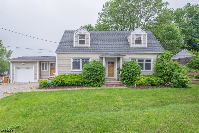 FALL IN LOVE with the interior craftsman style finishes. Charming custom Cape ideally located on a quiet dead-end street. Refinished HW floors throughout. Bright living room with gorgeous gas fireplace. Custom kitchen w/farmhouse sink, SS appliances, Vermont soapstone counters, cedar cabinets & formal dining. Versatile Mudroom space w/front & back walkout. Updated Baths in Arts & Crafts design, heated floors. Upstairs bdrms offer built ins & vaulted ceilings. BONUS walkout bsmt & family room. Cedar Closets-tons of storage plus 1 car garage & shed. Large, level fenced in lawn plus paver patio. Ductless Central air & Public Utilities. Built-in millwork throughout gives this home character that is hard to find JUST blocks from NYC Direct train station!