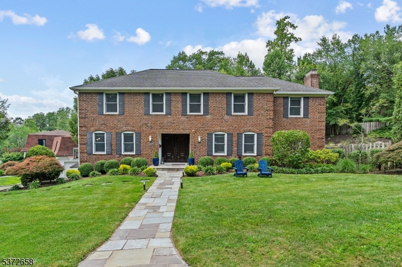 Beautifully maintained brick-front Colonial in a highly sought-after Short Hills neighborhood, just blocks from top-rated Deerfield Elementary. Blending timeless style with today's modern comforts, this home offers an open layout ideal for easy living and entertaining. Enter through a stone walkway and double doors into a welcoming foyer with hardwood floors and coat closet. The living room features hardwood floors and the spacious family room boasts two exposures of windows. Front-to-back dining room with a wood-burning fireplace and sliding doors to the backyard. Updated chef's eat-in kitchen shines with granite countertops, stainless steel appliances, custom cabinetry, built-in desk area and double sliding doors next to powder room opening to an oversized deck with built-in seating overlooking the private, tiered, fenced-in yard. Upstairs, the primary suite impresses with high ceilings, abundant storage including a walk-in closet + spa-like bathroom with double vanity, oversized shower and jacuzzi-style tub. 3 additional bedrooms, each with generous closets and natural light, share 2 full hallway bathrooms. Convenient 2nd floor laundry room adds ease to everyday living. Finished lower level provides a large recreation room, exercise area, office nook, multiple closets for storage, utility room, and direct access to attached 2-car garage. Perfectly located near NYC midtown direct trains, downtown Millburn, the Short Hills Mall and major highways.