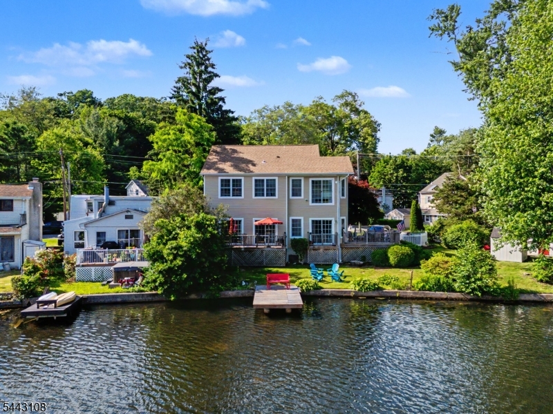 Dreaming of lakefront living? Welcome to this custom home, built in 2010 & perfectly positioned on a level lot along the shores of Indian Lake's Sunset Bay. Designed to maximize breathtaking water views, this thoughtfully crafted home offers an open-concept floor plan filled with natural light from a stunning wall of windows overlooking the lake. The heart of the home is the beautifully appointed gourmet kitchen, complete with a center island, SS appliances, stone countertops, abundant cabinetry, & a spacious pantry. The adjoining living & dining areas seamlessly flow to the expansive deck, creating the perfect setting for everyday living & effortless entertaining. Upstairs, the serene primary suite serves as a private retreat with panoramic lake views, a custom walk-in closet with built-ins, & a spa-inspired ensuite bath featuring dual vanities, a jetted soaking tub, & a separate glass-enclosed shower. 2 addtl bdrms, a beautifully updated full bath, & a convenient 2nd floor laundry room complete the upper level. HW flooring, oversized windows & timeless finishes add warmth & elegance throughout. Step outside & experience everything lake life has to offer. Deck, a fenced backyard, private dock, fire pit & direct access to the water create an incredible outdoor oasis for boating, kayaking, paddleboarding, fishing, or simply relaxing while enjoying spectacular sunsets over the lake with direct access to main lake under Franklin Rd bridge. Located just mins from vibrant DWTN.