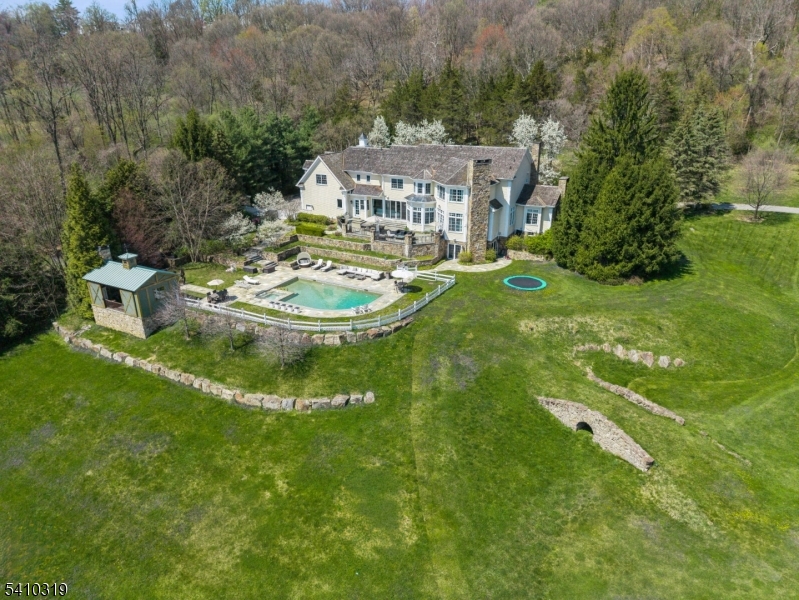 91 Mosle Road is a magnificent 7 bedroom, 8.1 bath estate showcasing exceptional craftsmanship, grand scale, and refined luxury. A dramatic two story foyer with herringbone hardwood floors and crystal chandelier opens to elegant living and dining rooms with intricate millwork, inlaid floors, and fireplaces. A richly paneled cherry office with custom built-ins and marble fireplace offers a distinguished workspace.The stunning 2024 Arclinea eat-in chef's kitchen features dual Sub-Zero refrigerators and freezers, multiple Wolf ovens and warming drawers, induction cooktop, Cove dishwashers, stainless counters, oversized center island with integrated dining table, built-in coffee bar, and separate prep kitchen. Walls of glass lead to the expansive bluestone patio and heated pool. The sunken great room with coffered ceiling and fieldstone fireplace creates a warm, inviting gathering space. Upstairs, the private primary suite wing offers vaulted ceilings, fireplace, sitting area, custom walk-in closets, and a spa-like bath with heated floors, soaking tub, and oversized shower. Five additional en suite bedrooms complete the level. The lower level is designed for entertaining with a pub-style bar and billiards room, climate-controlled wine cellar, theater with projector, gym, playroom, and walkout access. Resort-style amenities include a pool and spa, pool house with fireplace and kitchenette, gated entry, circular drive, Sonos system, generator, and 3.5-car garage.