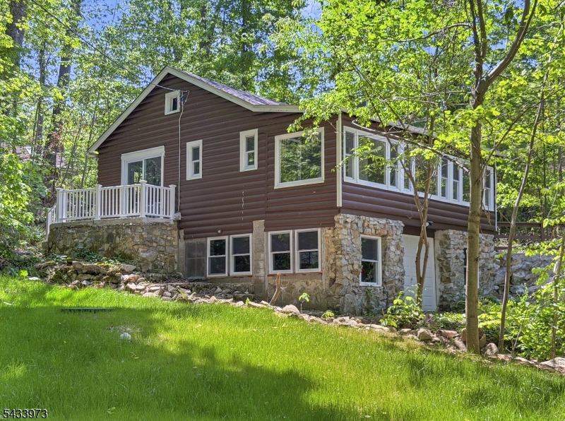 Welcome to this beautifully renovated 2-bedroom, 1-bath ranch tucked away in the desirable Lake Wallkill community of Vernon Township. From the moment you walk in, you'll appreciate that so much in the home has been updated. The bright, updated kitchen features brand new cabinets and stainless steel appliances, while new windows throughout the home fill the space with natural light. A brand new septic system and new culvert crossing over the stream will be completed prior to closing, offering added value and peace of mind.Step outside onto the peaceful patio off the kitchen and enjoy the calming sounds of the stream flowing through the property. Beyond the stream, you'll find a lush, park-like backyard perfect for relaxing, entertaining, or simply enjoying nature. The large one-car garage underneath the home offers plenty of room for parking, storage, or a workshop space.Lake Wallkill residents enjoy access to private lake amenities including swimming, boating, fishing, beaches, playgrounds, and community events. Conveniently located near Routes 23, 94, and 515, this home offers easy access to shopping, dining, hiking, golf, and nearby Mountain Creek Resort for year-round recreation. A wonderful opportunity to own a move-in ready home in a scenic lake community setting.