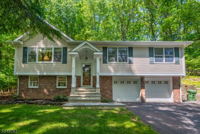 Nothing to do but move in and enjoy your privacy!  Low maintenance vinyl and brick exterior, well maintained! Kitchen, living room and dining room are open concept with updated kitchen featuring stainless appliances and granite center island, hardwood floors, extensive moldings, recessed lighting, designer railings, large main bath with tub/shower and skylight, primary bedroom, 2 additional bedrooms and pull down stairs to attic storage.  Lower level offers laminate flooring, wood burning stove, powder room, laundry room and access to oversized 2 car garage.  Deck overlooks complete wooded privacy in rear yard.  Highly regarded Cucinella elementary, LV Middle School and West Morris Central High School with IB Program.  Excellent location, convenient to Chester.