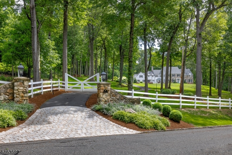 Picturesque Bernardsville Mountain is the setting for this custom Bucks County-inspired colonial. With inviting entertaining spaces, inside and out, and rooms that welcome in views, this 5.3-acre residence embraces every square foot as an opportunity to live beautifully. Through the gated entry, the escalating driveway draws the eye to the magnificent grounds and stunning exterior of stone and clapboard. The generously sized updated designer kitchen includes 2 islands and top-of-the-line appliances including a La Cornue French range. The large primary suite provides a fireplace, 2 walk-in closets, and an updated bathroom with dual vanities, large glass-enclosed shower, and soaking tub. Four additional bedrooms with updated baths and sitting room are also found on the 2nd level. The finished lower level comprises the media, exercise and wine rooms, as well as a full bath and large recreation room. Fieldstone walls, heated pool with spa, fireplace, and bluestone patios complete the prime setting. Close proximity to shopping and dining in downtown Bernardsville, NJ Transit train and easy access to Rt 78 & 287.